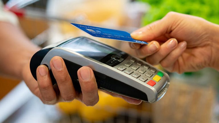 manos haciendo un pago con tarjeta visa