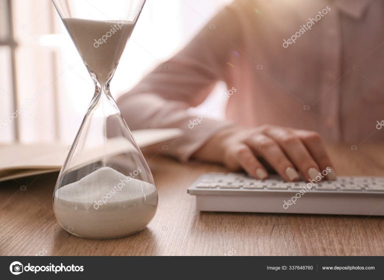 reloj de arena sobre una mesa de trabajo